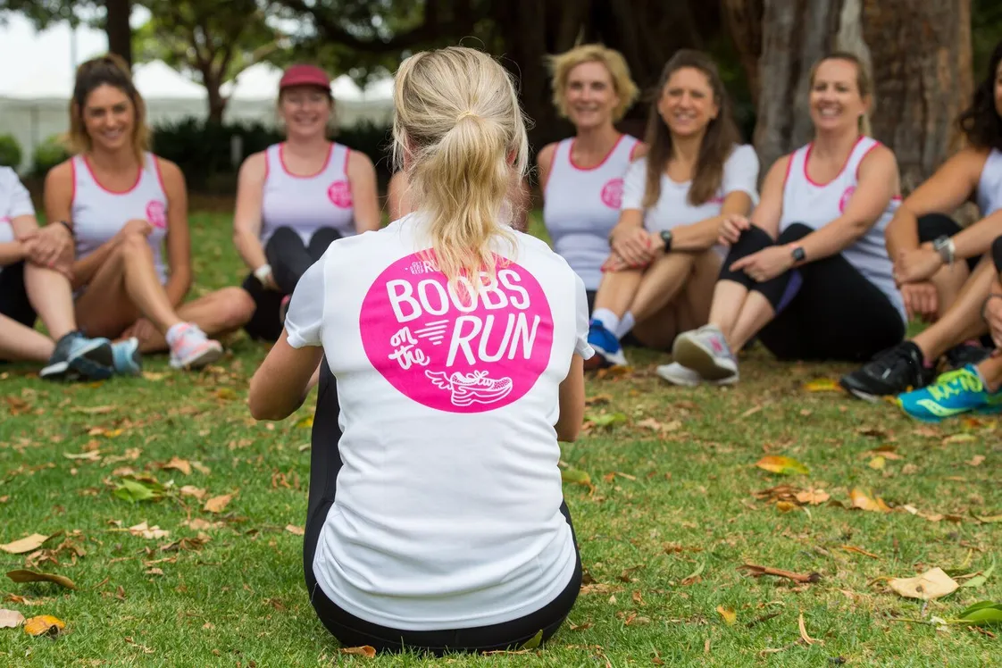 A diverse seated group of women who are members of Boobs on the Run